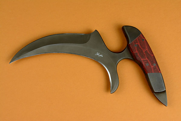 "Chela" karambit knife, obverse side view in T4 cryogenically treated 440C high chromium martensitic stainless steel blade, 304 stainless steel bolsters, red and black tortoiseshell G10 composite handle, leather sheath with stainless steel and nylon