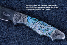 "Thuban" obverse side view in hot-blued 1095/nickel damascus blade, hand-engraved 304 stainless steel bolsters, Shattuckite gemstone handle, hand-carved, hand-dyed leather sheath