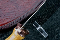 "Edesia" fine chef's cleaver, front ferrule guard detail. the reflection of the camera can be seen in the polished copper fittings