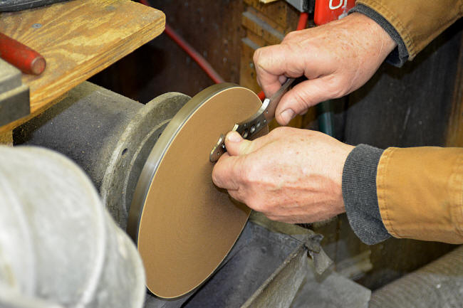 Disk grinding a knife tang with abrasive sheet